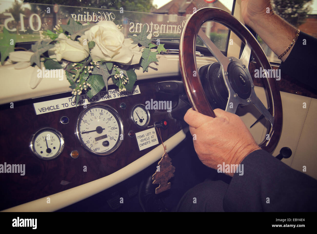 Intérieur d'une voiture de mariage avec les mains sur le volant. Banque D'Images