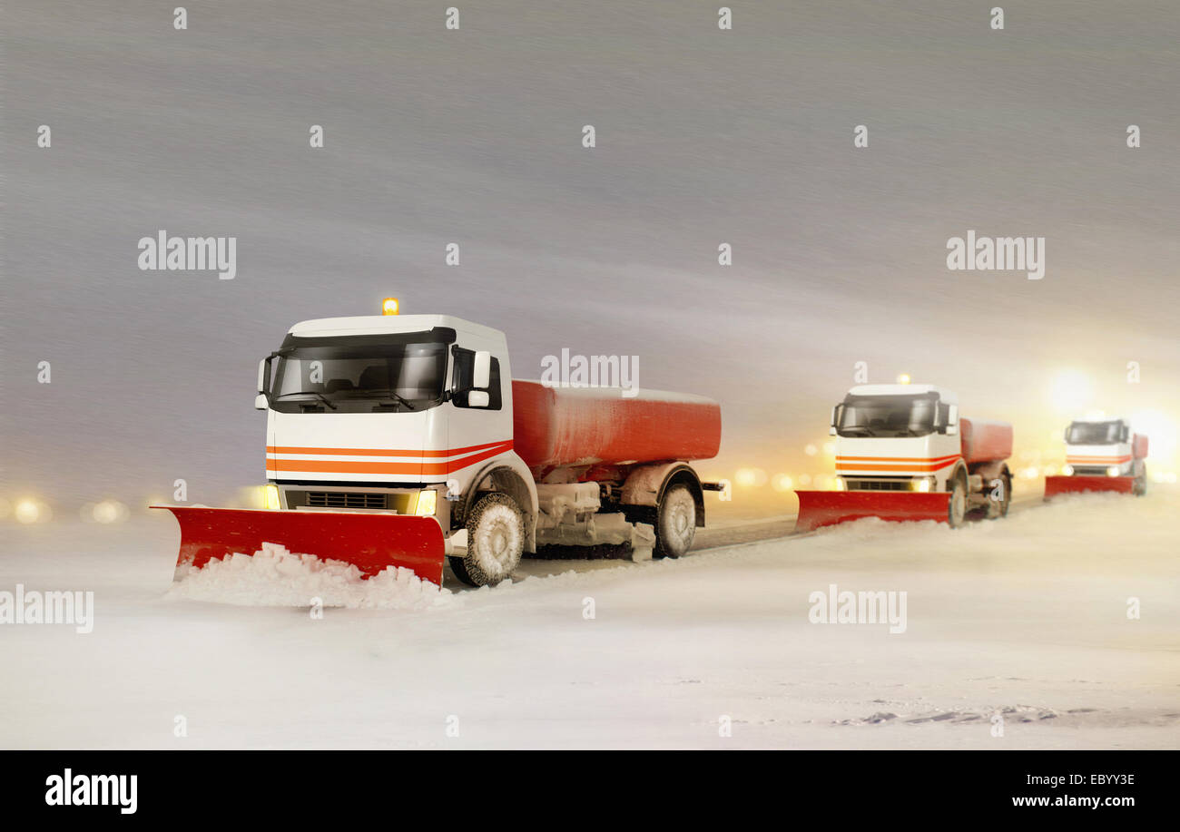 Les camions de déneigement de retirer la neige à partir de l'autoroute pendant une tempête de neige froide journée d'hiver Banque D'Images