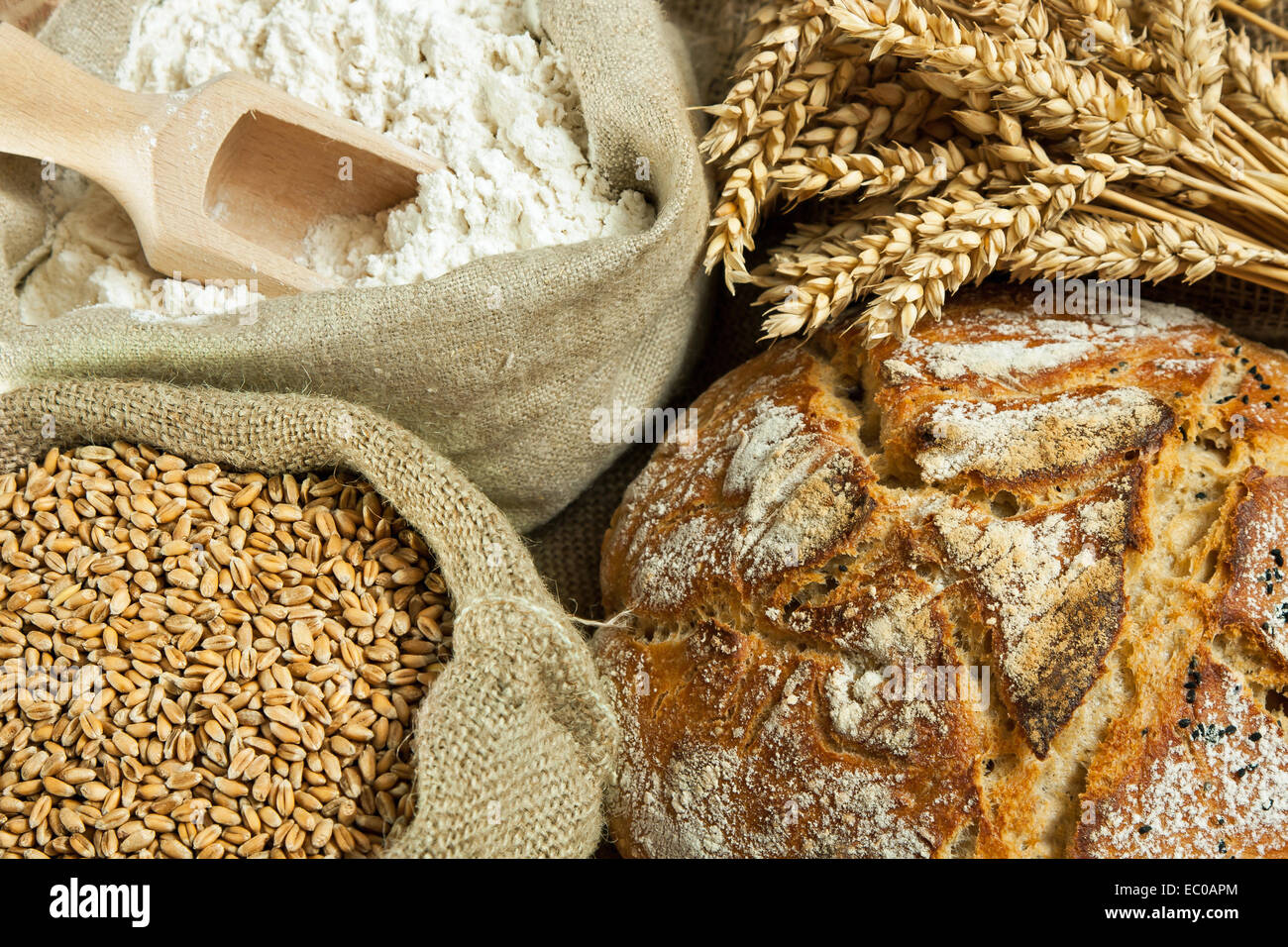 Miche de pain, de farine, le grain de blé et blé spike sur table Banque D'Images