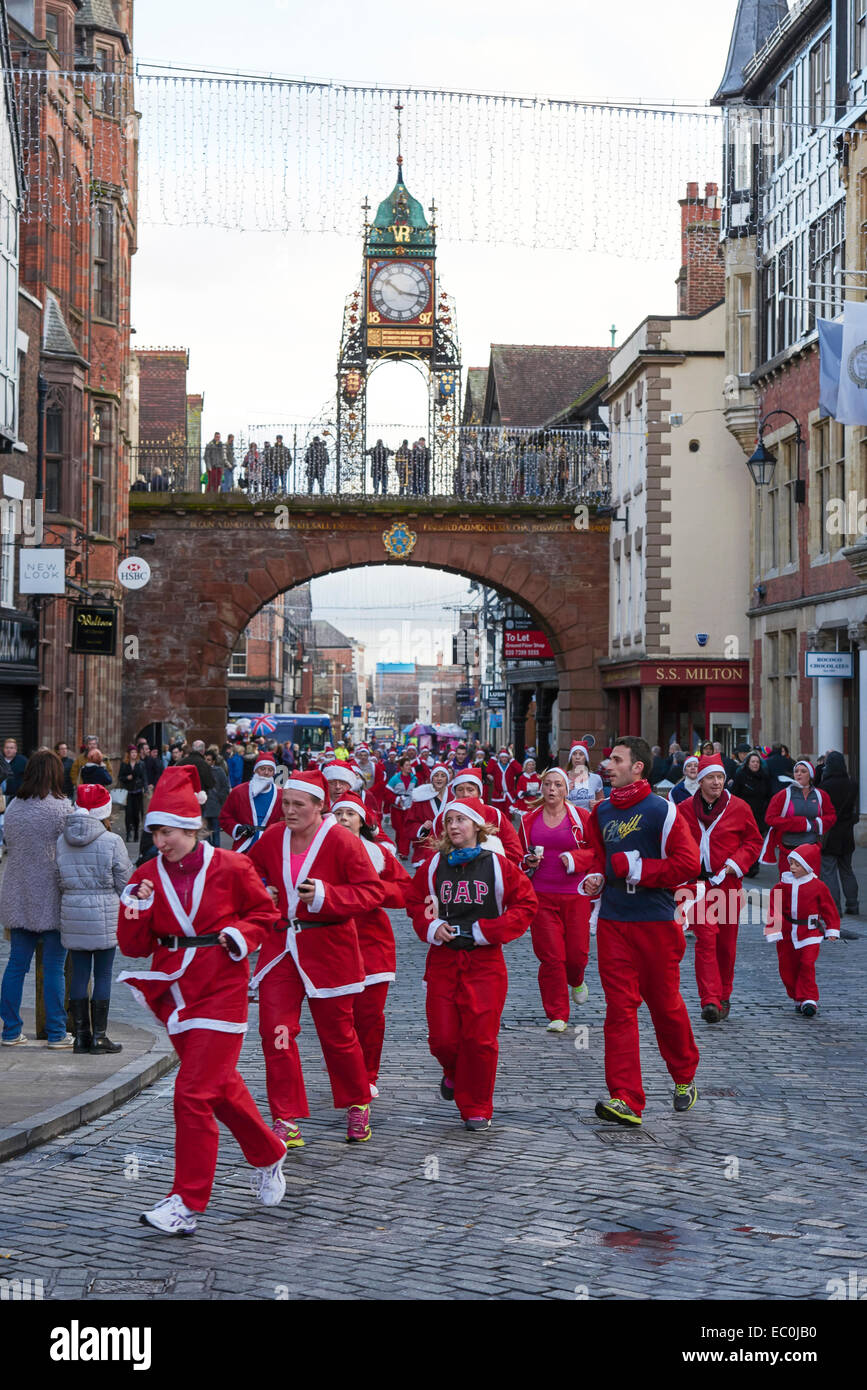 Chester, Royaume-Uni. 7 Décembre, 2014. Les concurrents passer sous l'Eastgate Clock dans la charité 2014 Santa Dash à travers les rues du centre-ville de Chester UK. Crédit : Andrew Paterson/Alamy Live News Banque D'Images