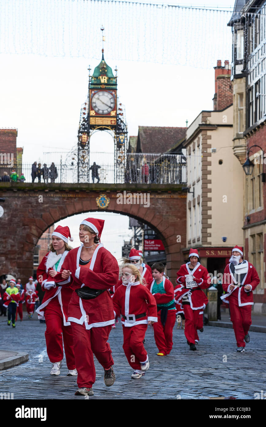 Chester, Royaume-Uni. 7 Décembre, 2014. Les concurrents passer sous l'Eastgate Clock dans la charité 2014 Santa Dash à travers les rues du centre-ville de Chester UK. Crédit : Andrew Paterson/Alamy Live News Banque D'Images