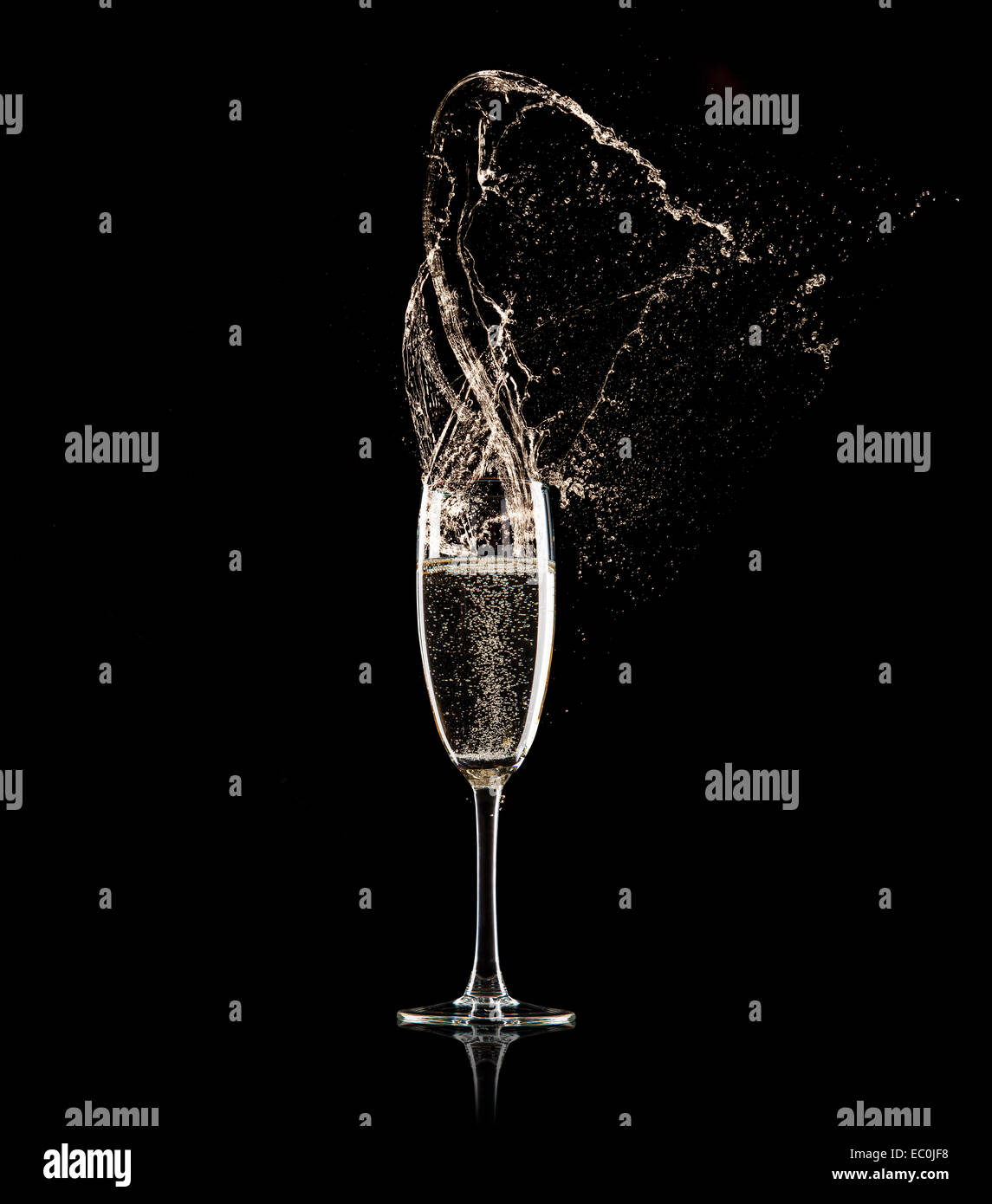 Verre de champagne avec splash, isolé sur fond noir Banque D'Images