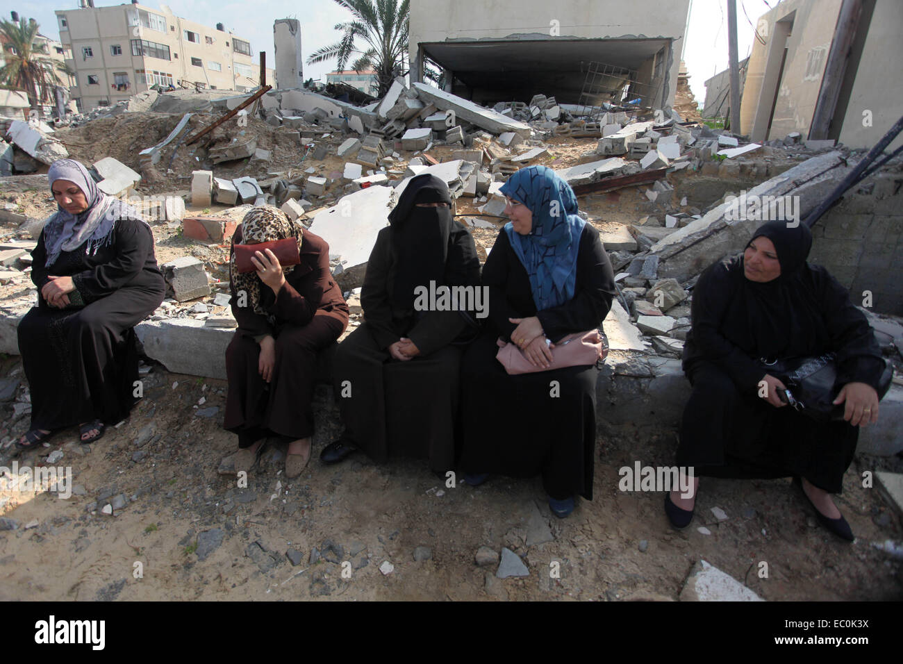 La ville de Gaza, bande de Gaza, territoire palestinien. 7 Décembre, 2014. Les Palestiniens partisans du Front populaire de libération de la Palestine (FPLP) s'asseoir à côté du bâtiment endommagé lors d'une protestation contre le retard dans l'acquisition de matériel de construction en face de l'Office des Nations Unies à Gaza le 7 décembre 2014. Des responsables palestiniens ont déclaré le mois dernier, qu'au moins 100 camions de matériaux de construction par jour sont nécessaires pour achever la reconstruction de Gaza dans les trois années de crédit : Ashraf Amra/APA/Images/fil ZUMA Alamy Live News Banque D'Images