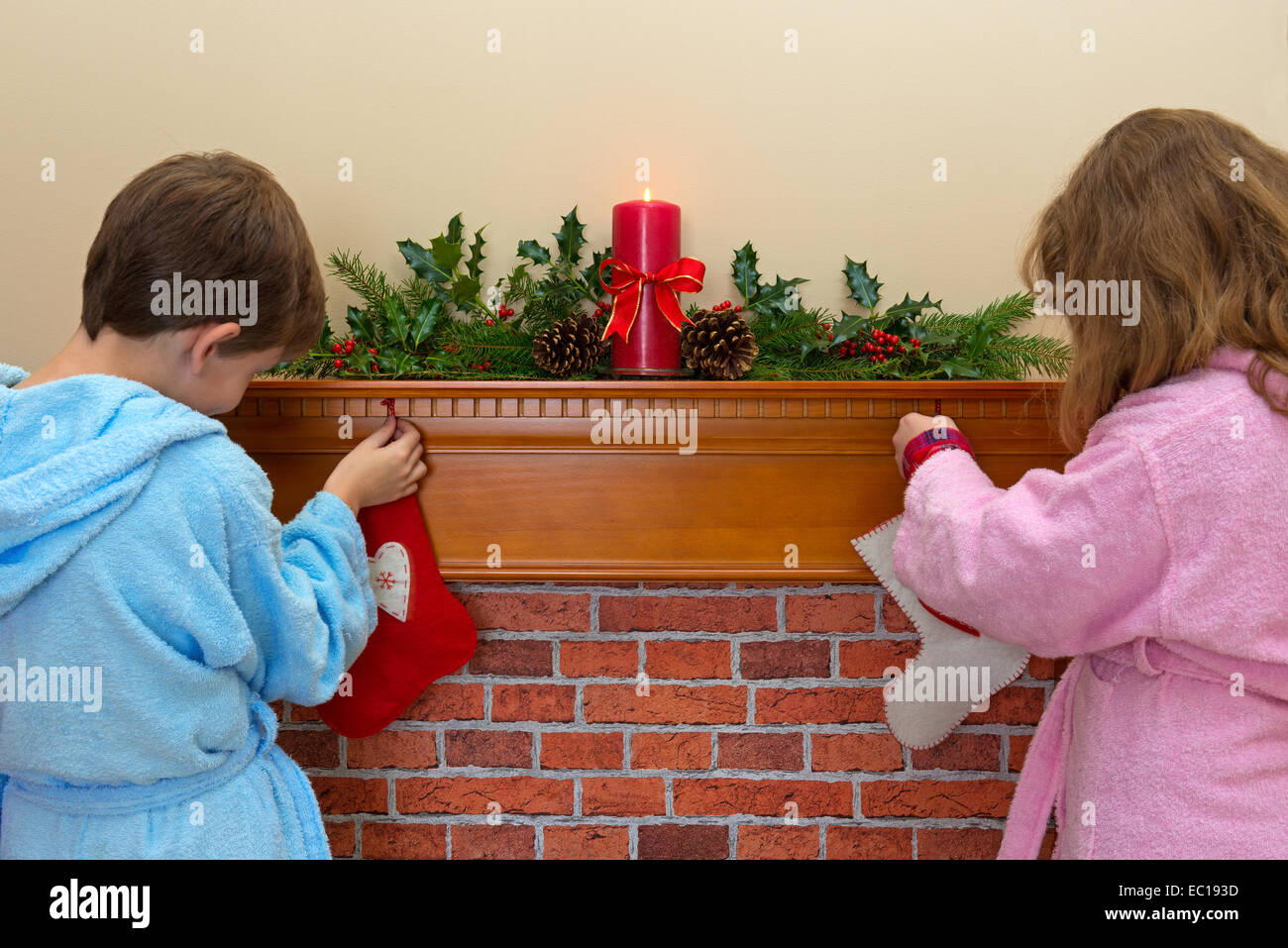 Un garçon et une fille accroché leurs bas sur la cheminée la veille de Noël Banque D'Images