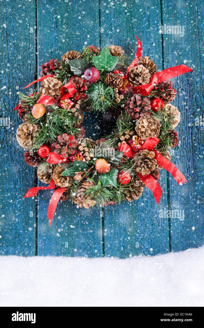 Christmas wreath on a rustic porte verte dans la neige Banque D'Images