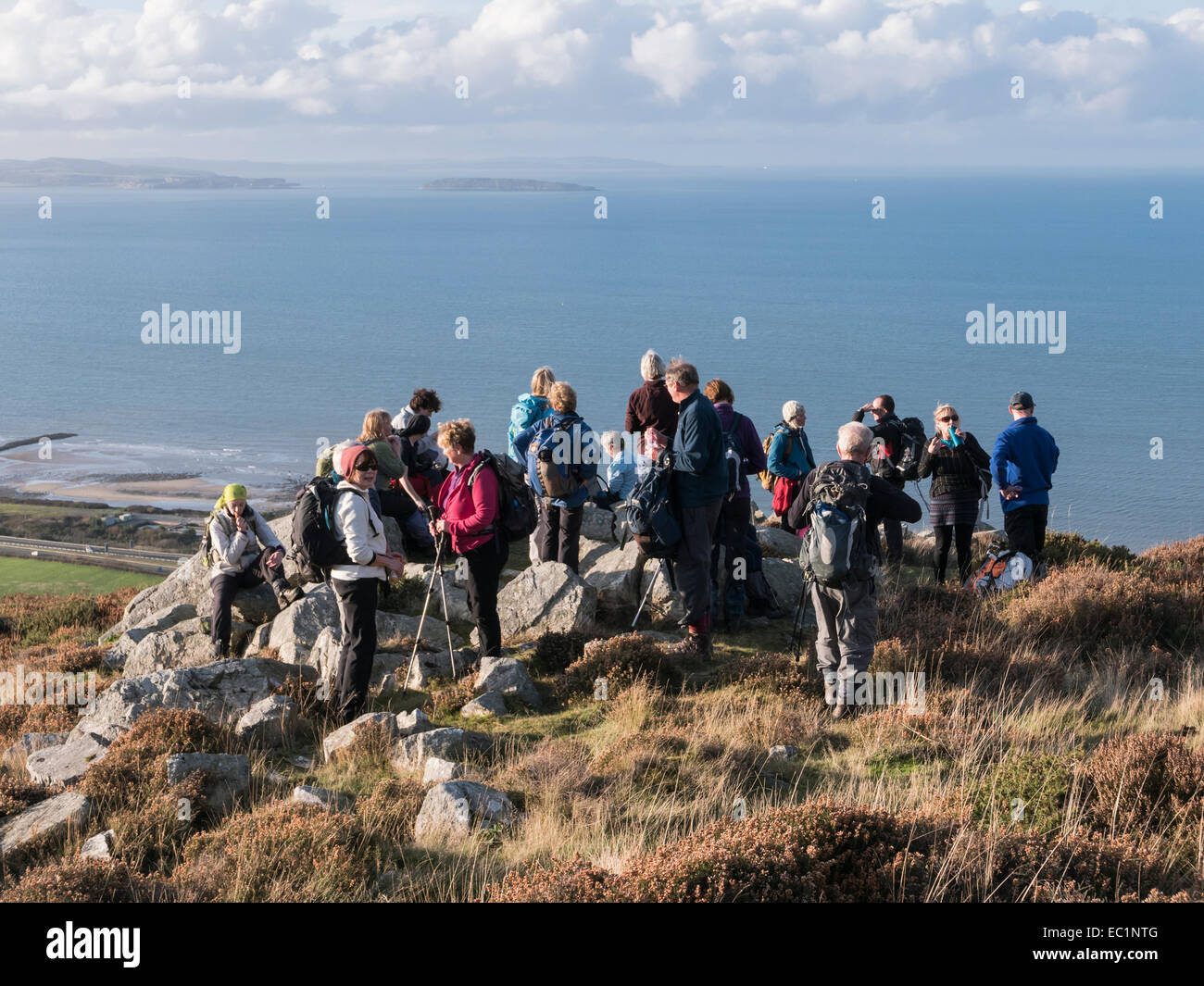 Groupe de randonneurs se reposant avec une vue sur la côte galloise et au-dessus d'Anglesey Penmaenmawr, Conwy, au nord du Pays de Galles, Royaume-Uni, Angleterre Banque D'Images