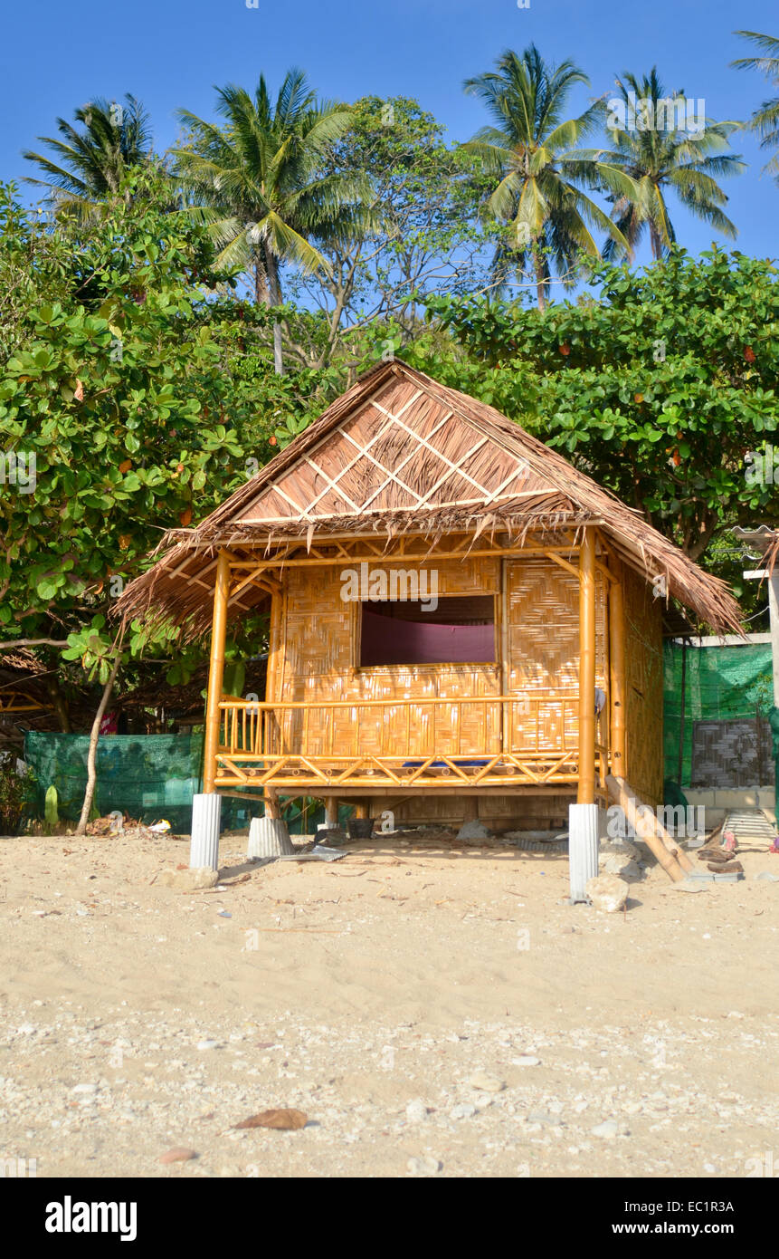  Cabane  de  plage en bambou sur pilotis avec des palmiers 