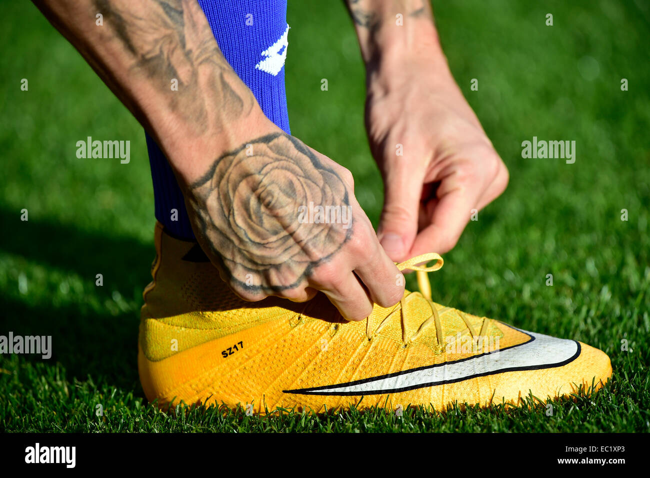 Football player lier les lacets de ses chaussures, tatouage Banque D'Images
