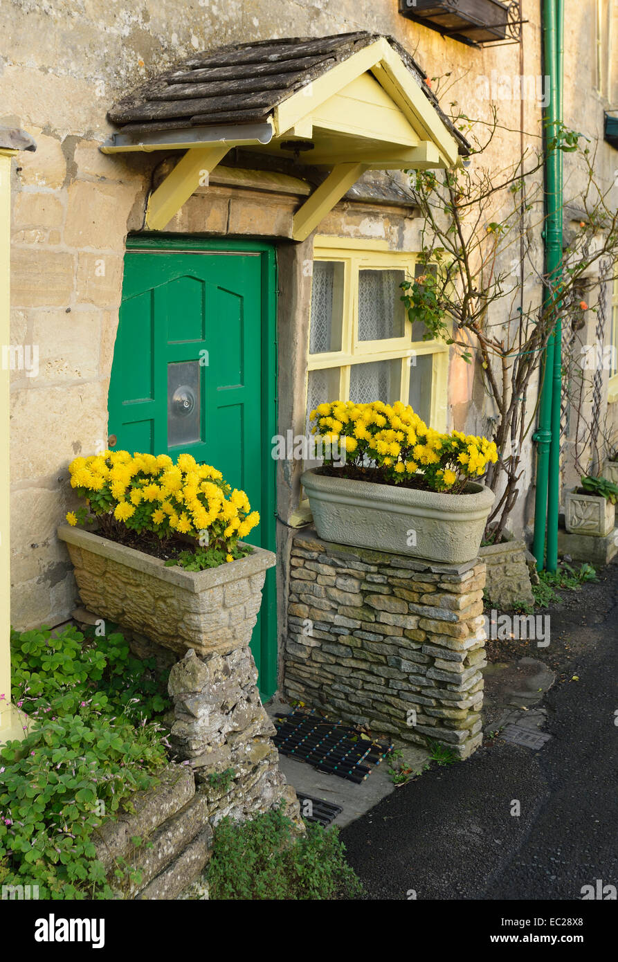 Cotswold Cottage vert avec des fleurs jaunes de porte Banque D'Images