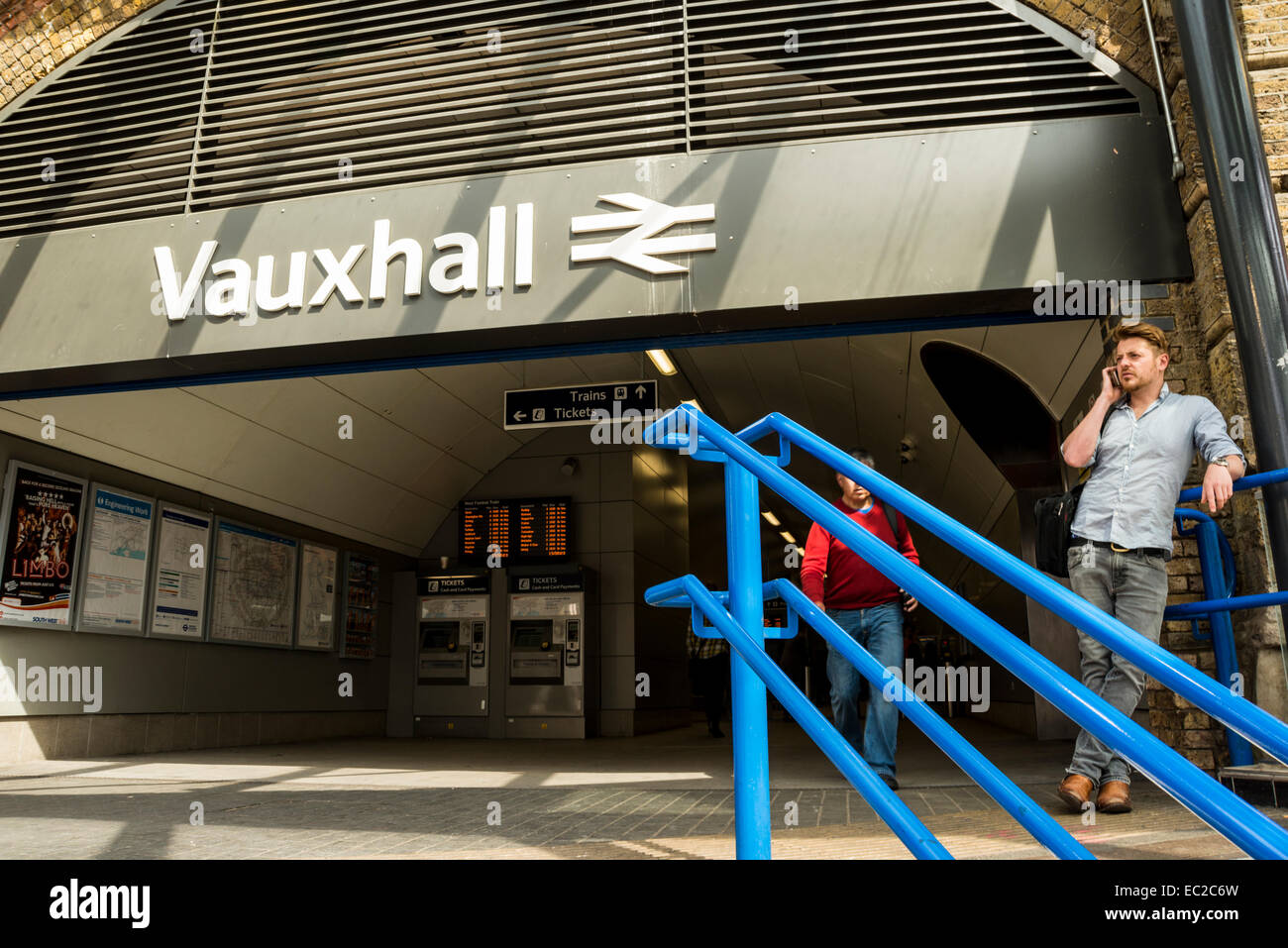 Un man talking on mobile phone à l'entrée de la gare de Vauxhall à Londres, UK National Banque D'Images