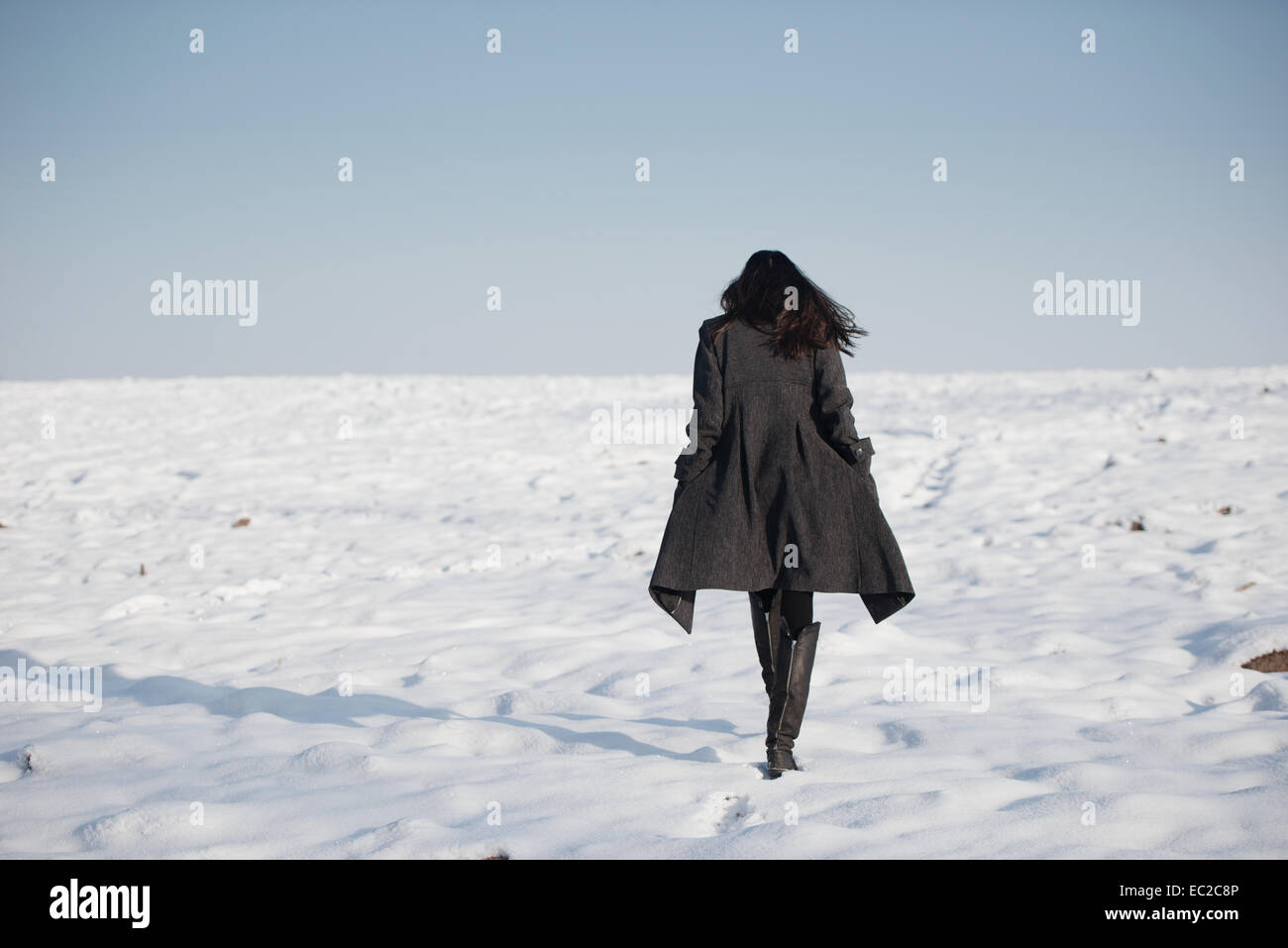 Belle jeune fille seule dans le champ d'hiver Banque D'Images