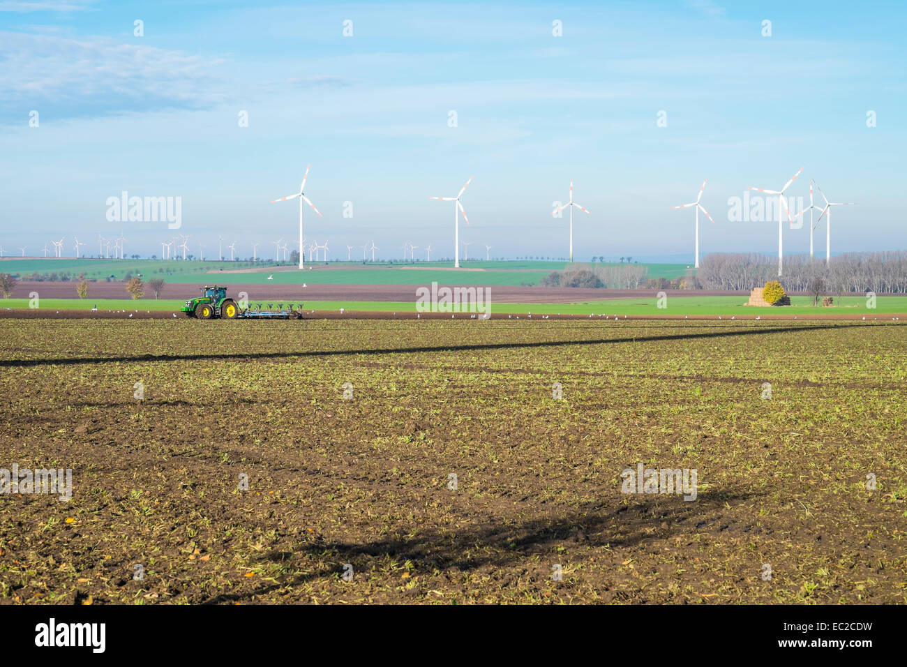 L'agriculture et de l'industrie de l'énergie - Tracteur labourant les champs partagés avec un parc d'éoliennes en Saxe-Anhalt, Terre Manfelder Banque D'Images