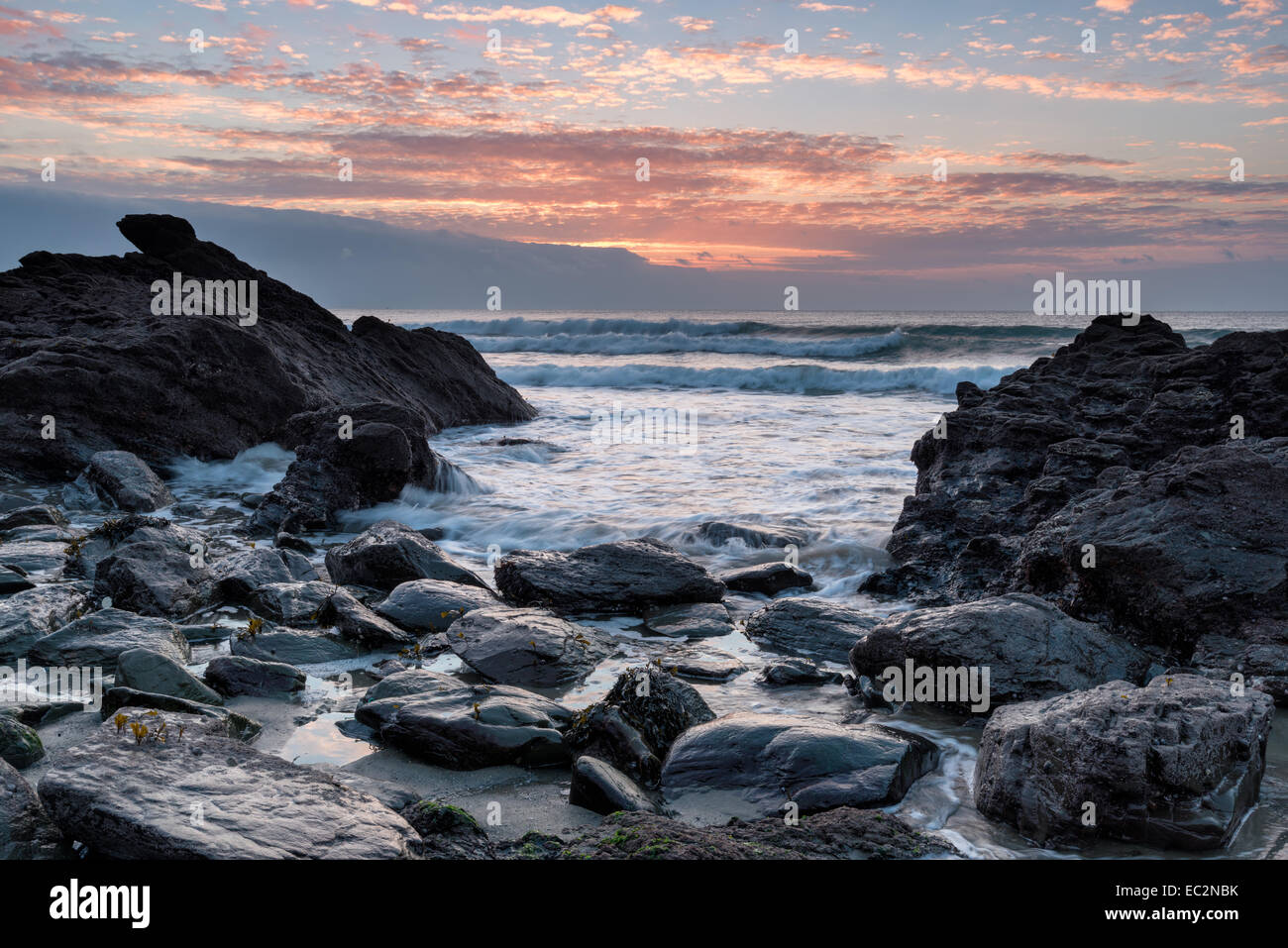 Un lever de soleil sur l'Portholland orageux beach sur la côte sud des Cornouailles Banque D'Images