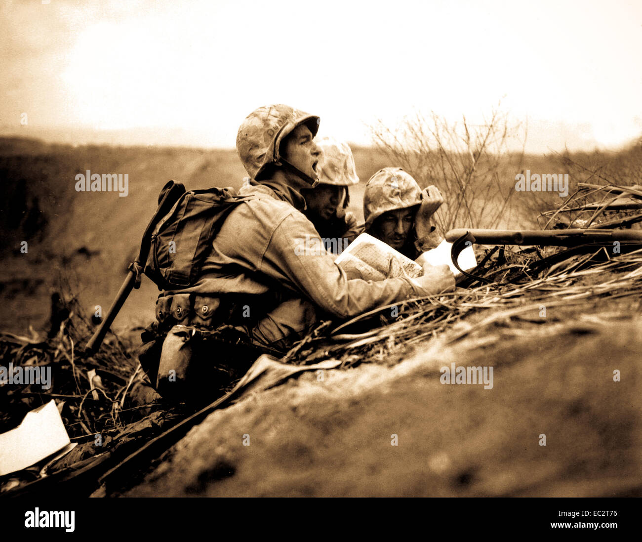 Observateur qui a repéré un nid de mitrailleuse trouve son emplacement sur une carte afin de pouvoir envoyer les informations à l'artillerie et des mortiers d'éliminer le poste. Iwo Jima, février 1945. Dreyfuss. (Marine Corps) Banque D'Images