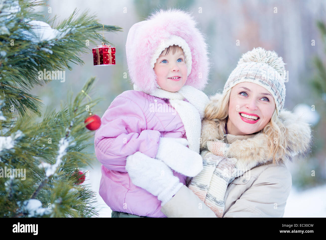 Heureuse mère et l'enfant avec l'arbre de Noël décoré outdoor hiver Banque D'Images