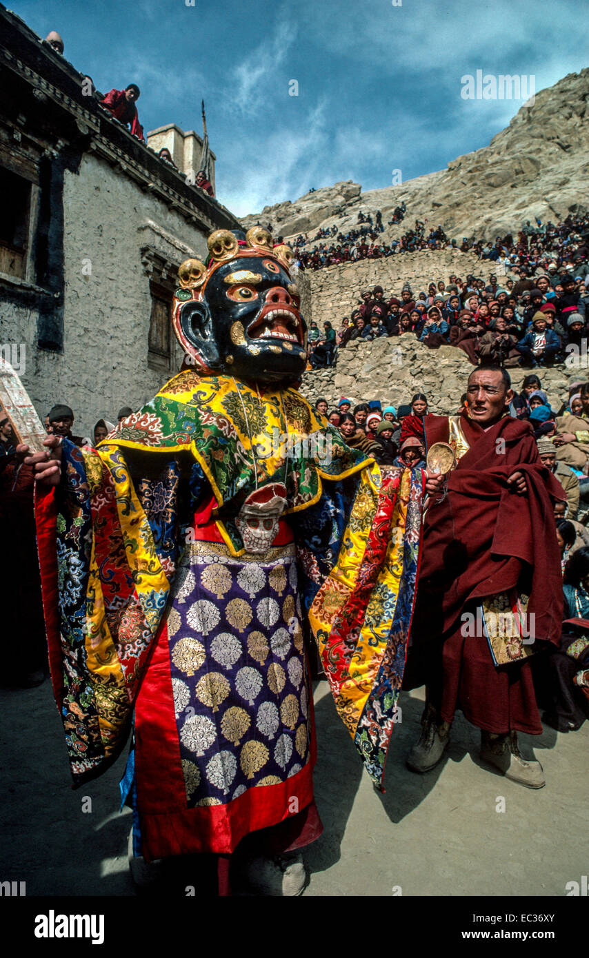 Tibet Leh danse Cham Mahakala déité crâne noir moine masque coloré des robes de soie des foules de personnes regardant des montagnes Banque D'Images
