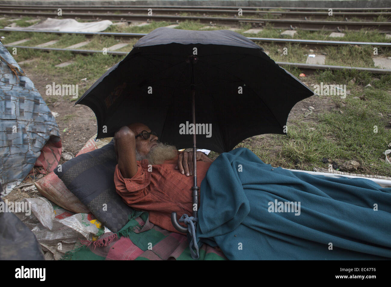 Dhaka, Bangladesh. 9Th Mar, 2014. Un vieil homme étendu près de la ligne ferroviaire à Kamalapur slum Dhaka.Un total de 3,5 millions de personnes vivent dans des taudis, à 4 000 de la Dhaka metropolitan area.les taudis ont été expulsées sans toute réhabilitation et maintenant en hiver, elles souffrent beaucoup.Journée internationale des droits de l'homme 2014 slogan ''Les droits de l'homme 365'' par l'Organisation des Nations Unies. Zakir Hossain Chowdhury Crédit : Fil/ZUMA/Alamy Live News Banque D'Images