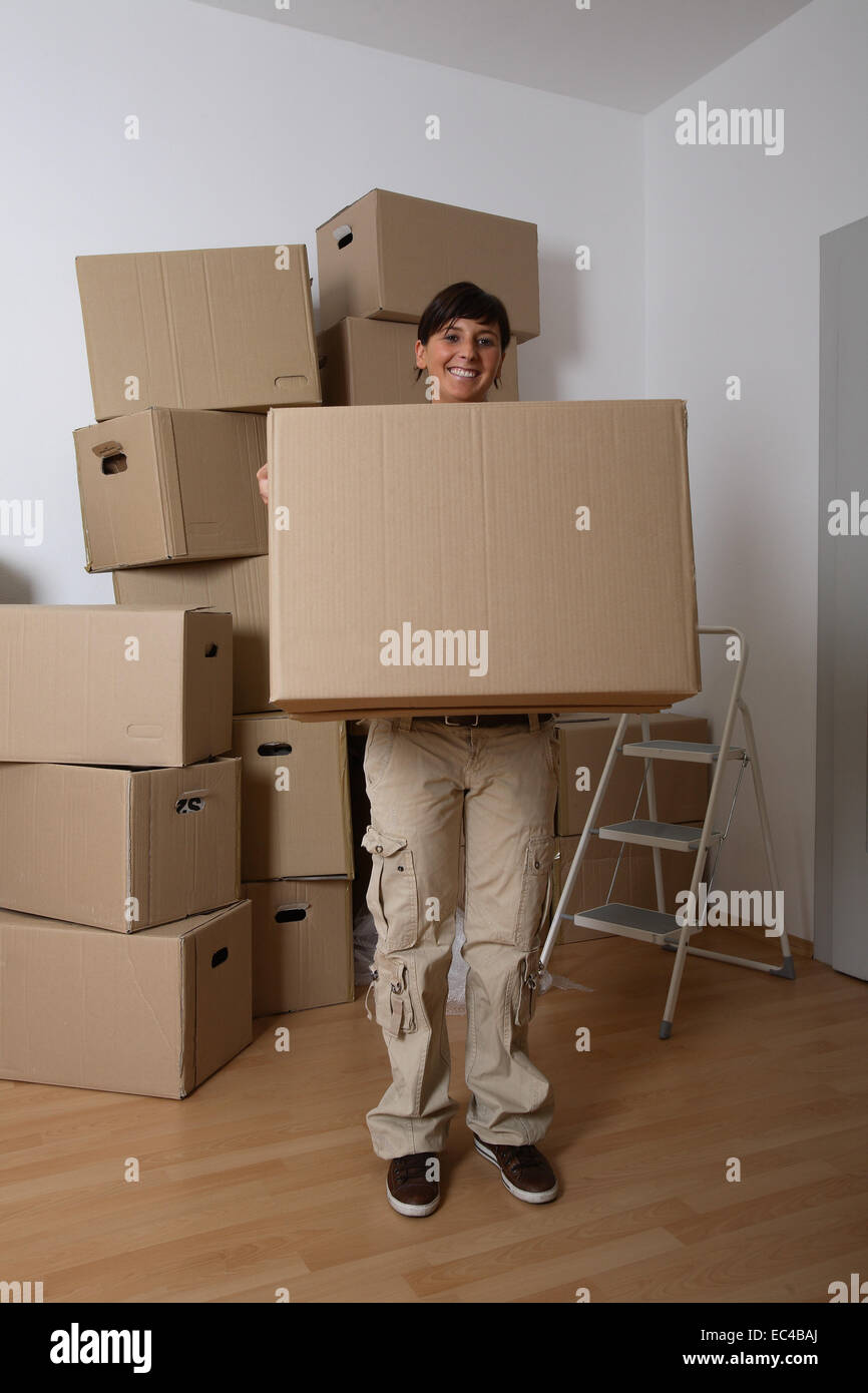 Jeune femme portant un déménagement fort Banque D'Images