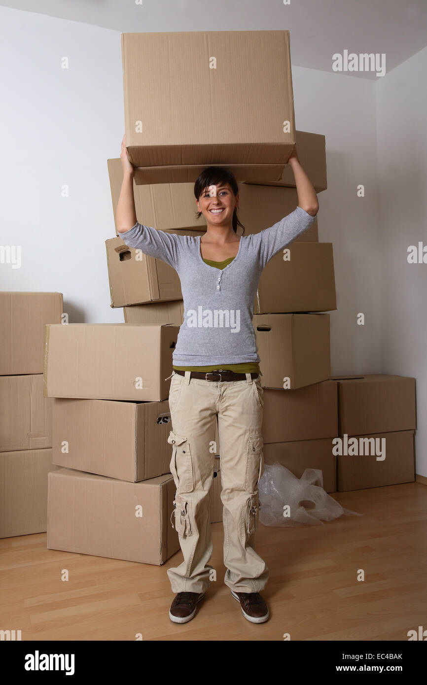 Jeune femme portant un déménagement fort Banque D'Images