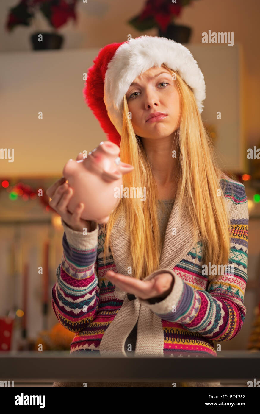 Portrait de jeune fille adolescente déplut à santa hat avec piggy bank Banque D'Images