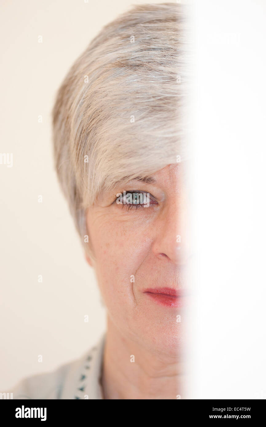 Portrait d'une femme derrière une feuille de papier Banque D'Images