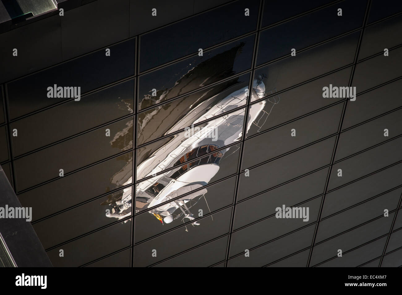 Réflexion d'un yacht à moteur blanc dans la façade d'un gratte-ciel noir Banque D'Images
