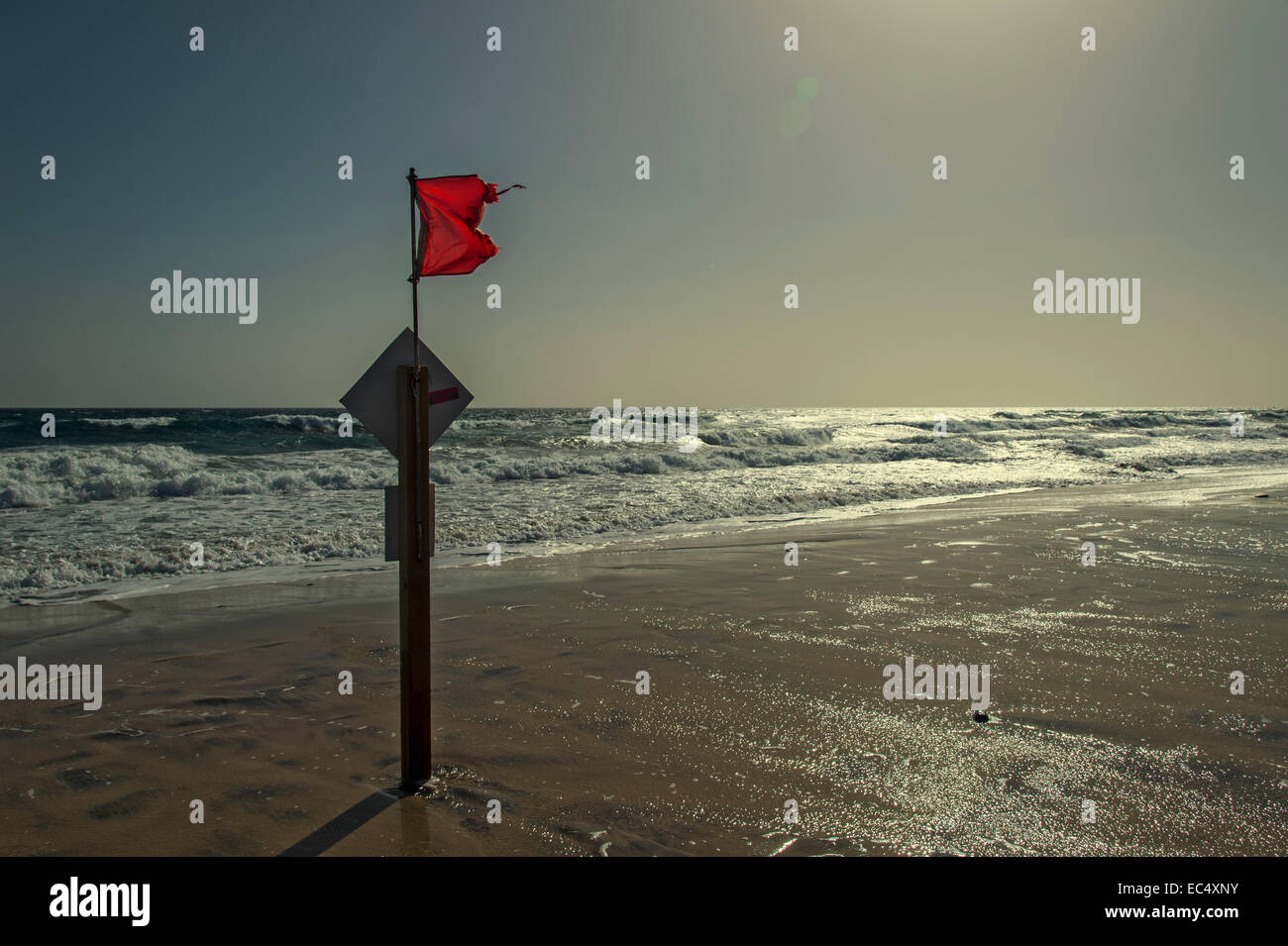 Interdiction de baignade signe et drapeau rouge contre la lumière sur la plage Banque D'Images