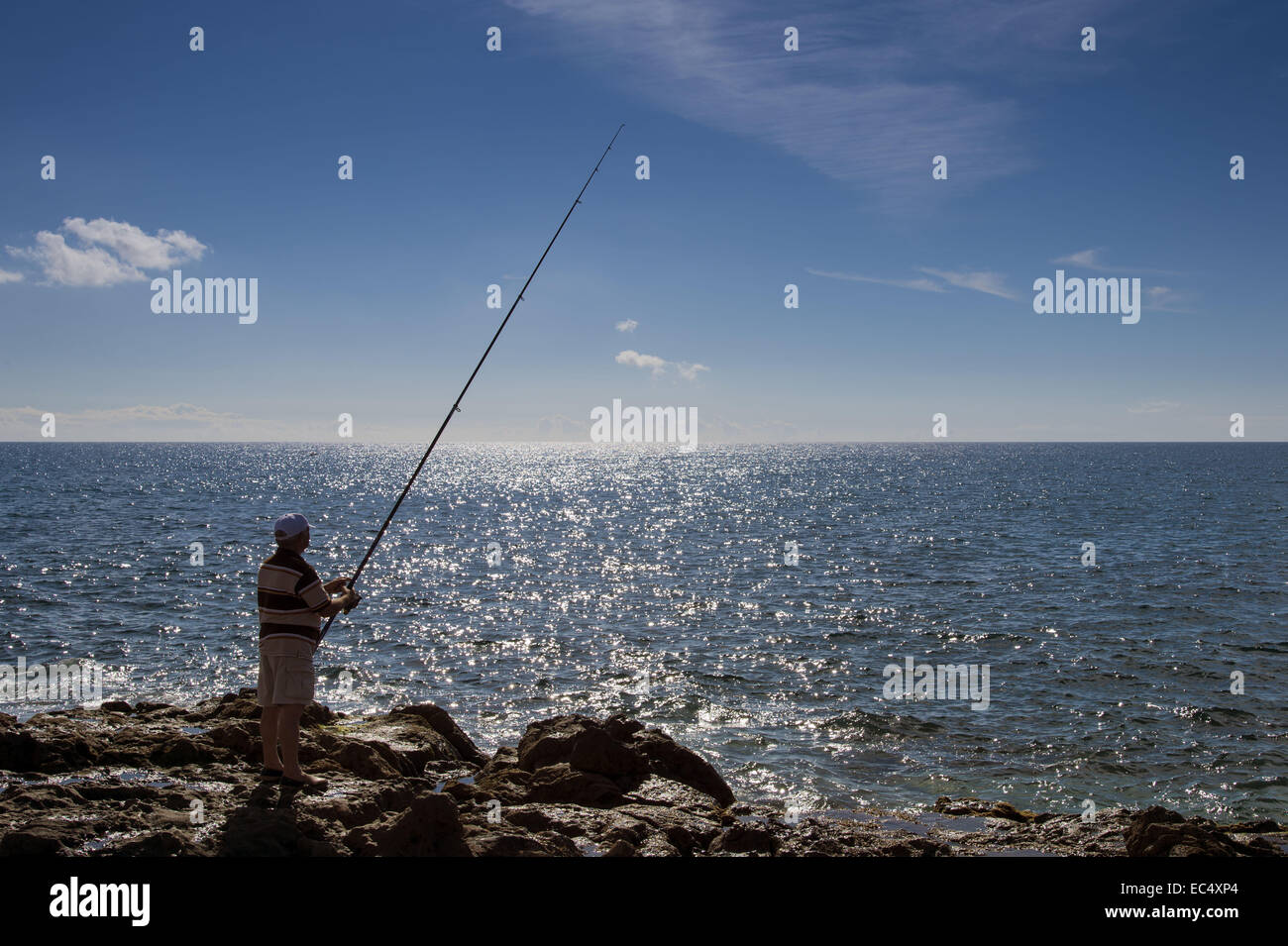 Un pêcheur sur la côte rocheuse de San Agustin, Gran Canaria Banque D'Images