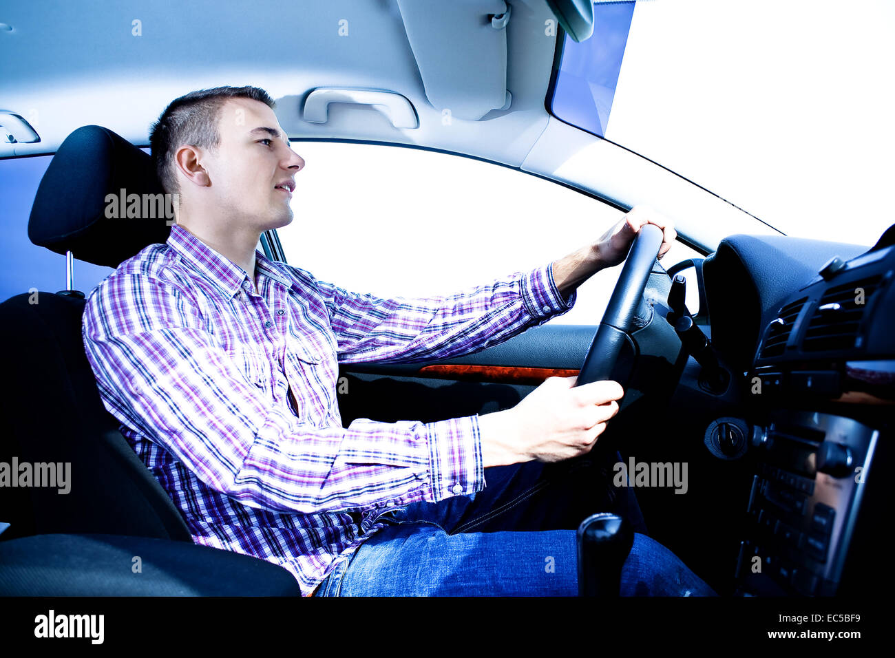 Un jeune homme au volant de la voiture Banque D'Images