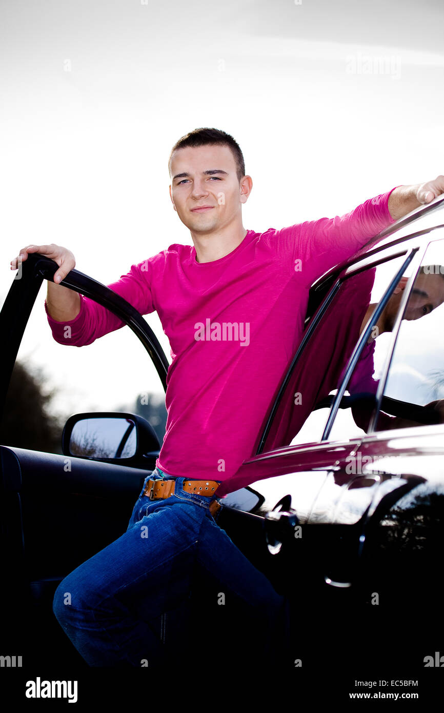 Un jeune homme posant avec la voiture Banque D'Images