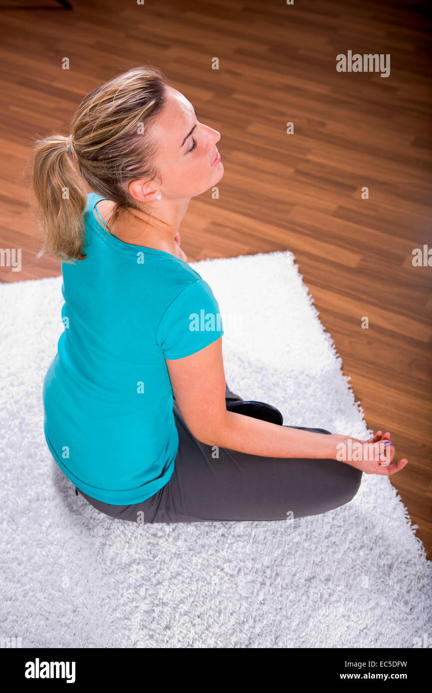 Jeune femme faisant de l'exercice de yoga à la maison Banque D'Images