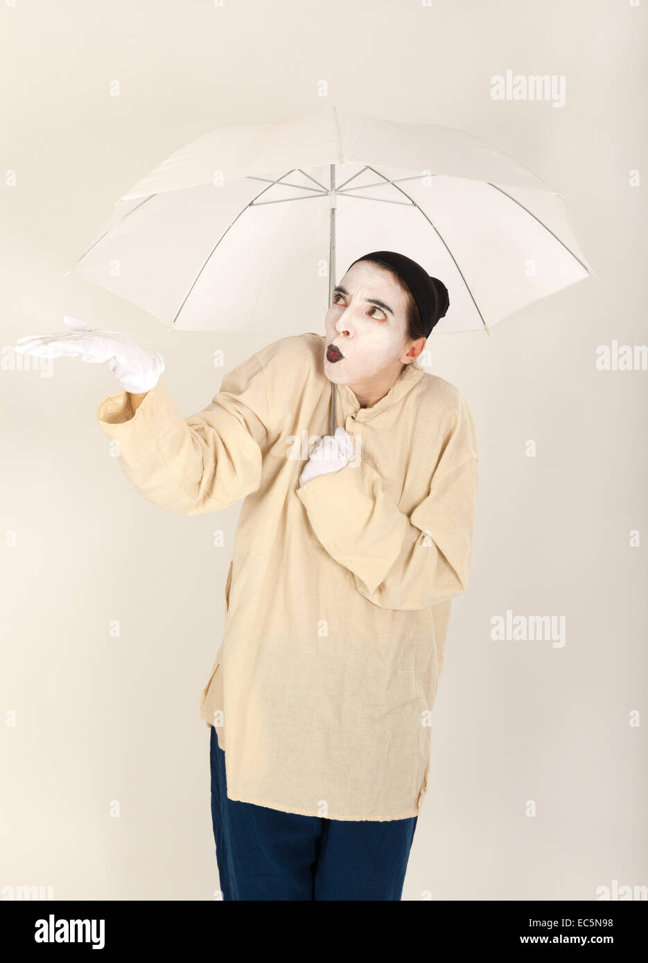 Le clown tenant un parapluie blanc dans la main Banque D'Images