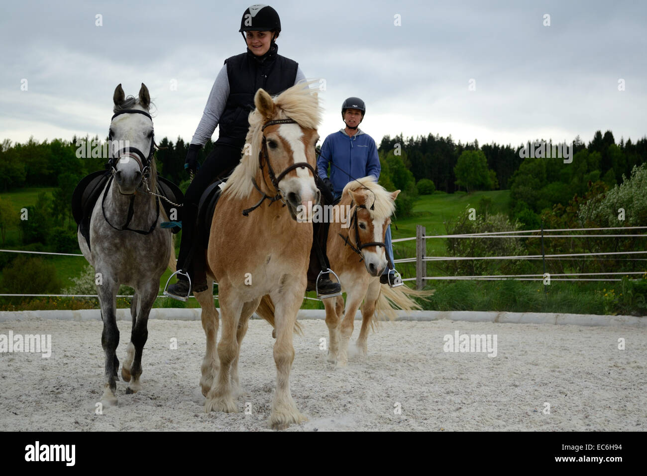 Deux cavaliers avec trois chevaux Banque D'Images