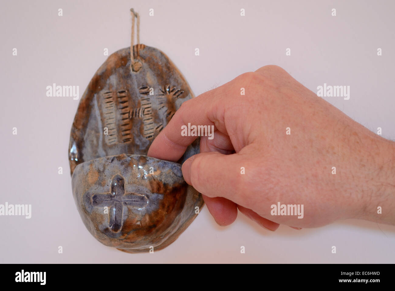 Personne trempant les doigts dans l'eau bénite Banque D'Images
