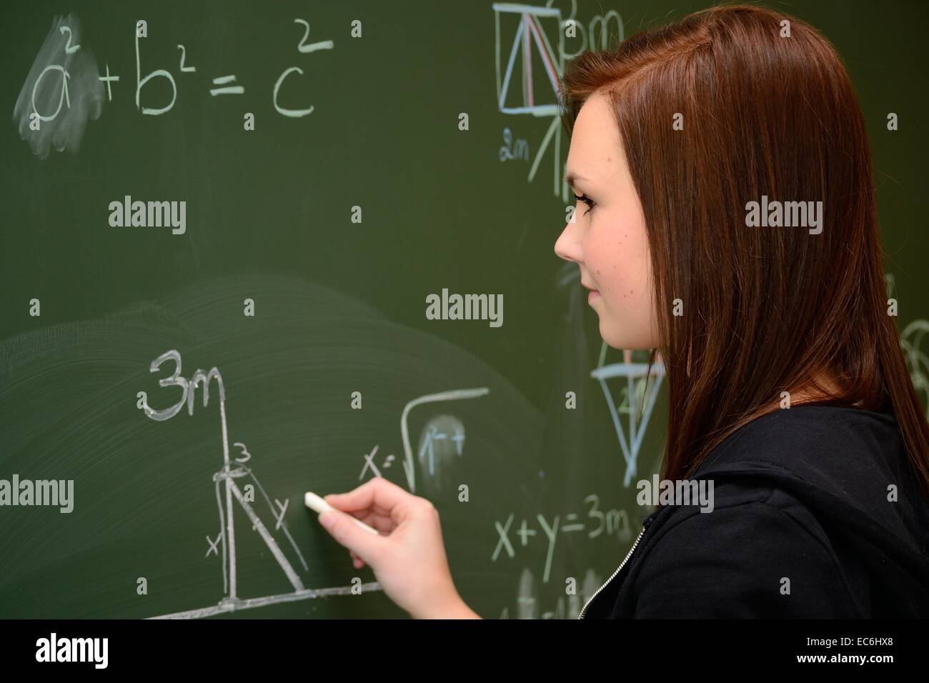 Adolescent dans les calculs sur un tableau noir de l'école Banque D'Images