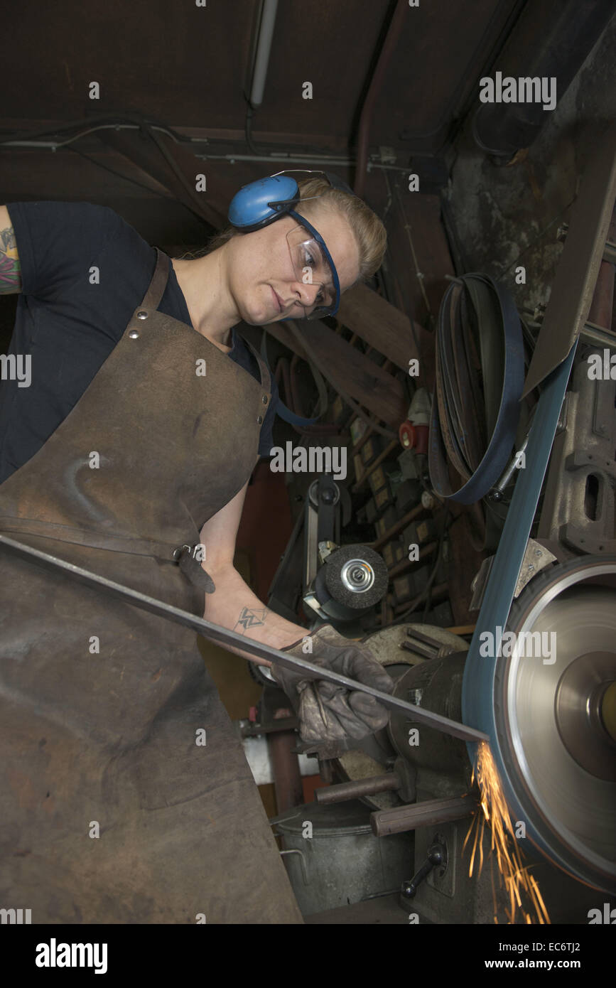 Jeune femme travaillant au moulin de forgeron Banque D'Images
