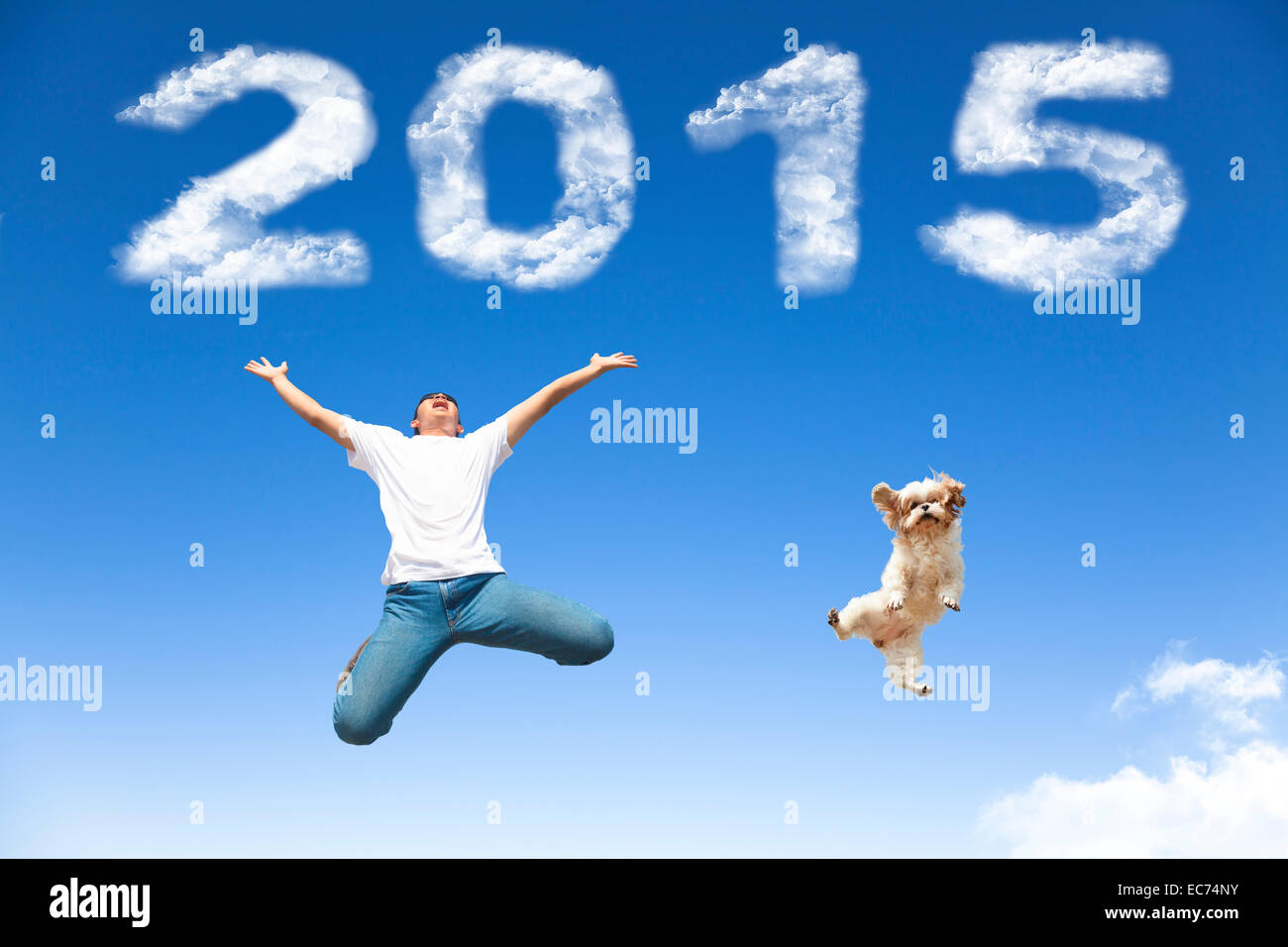 Bonne année 2015.jeune homme et chien sautant avec fond de ciel bleu Banque D'Images