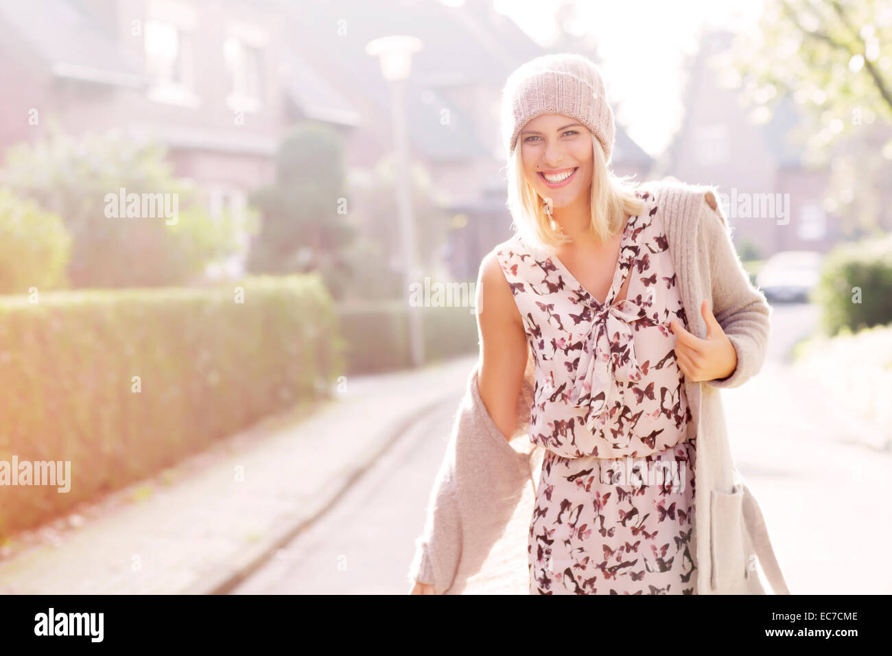 Portrait of smiling blond woman wearing robe à motifs, Cardigan et cap laine Banque D'Images