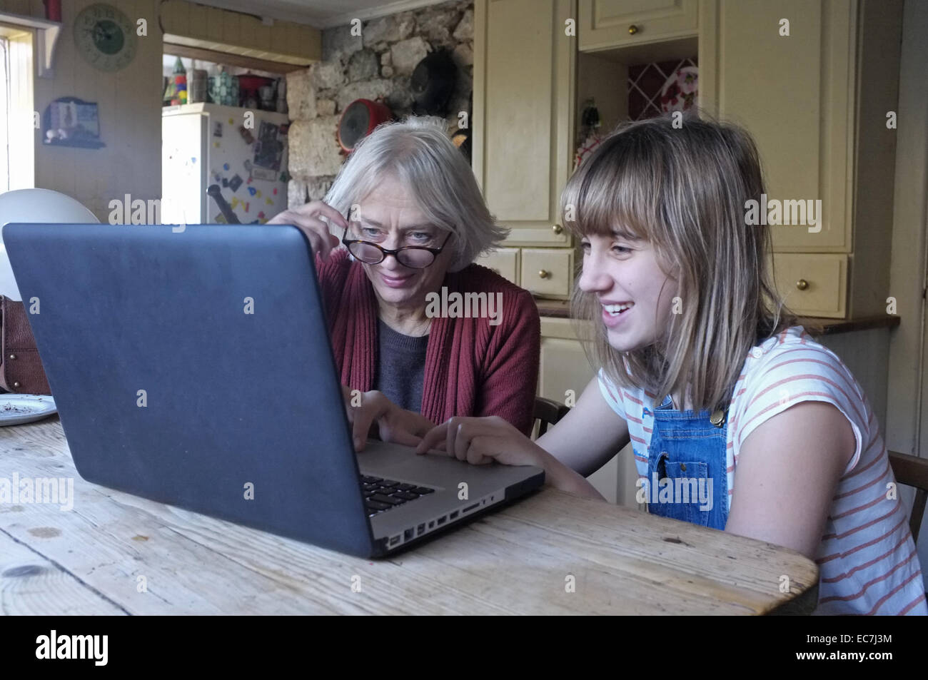 Une jeune fille de 11 ans, sa grand-mère apprend à utiliser un ordinateur Banque D'Images