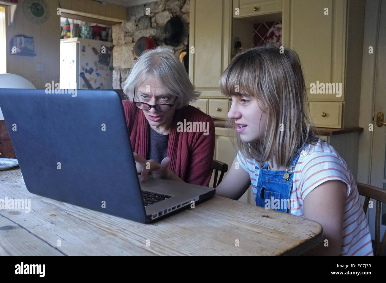Une jeune fille de 11 ans, sa grand-mère apprend à utiliser un ordinateur Banque D'Images