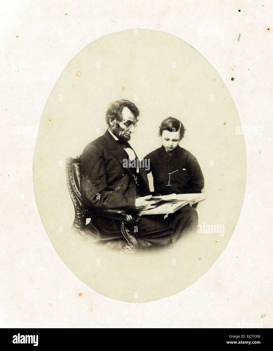 Abraham Lincoln, président des États-Unis, à la recherche d'un album photo avec son fils, Tad Lincoln. Comme le seul portrait de lui porter des lunettes ce portrait a été l'une des plus largement distribué de Lincoln. Banque D'Images