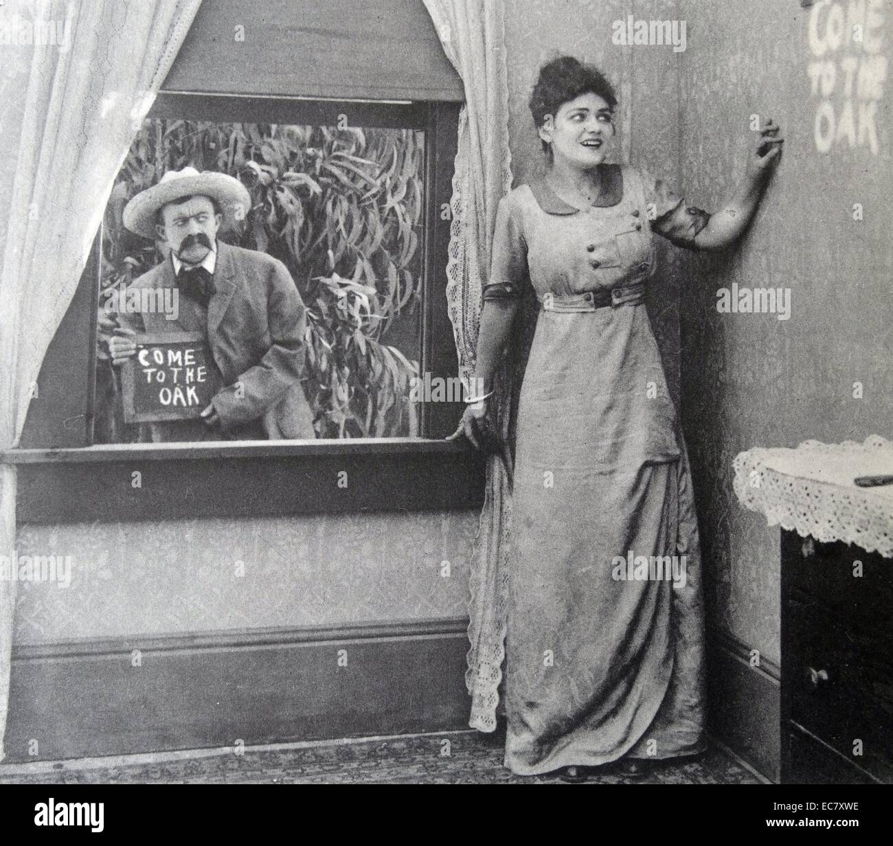 Une cession dans un film intitulé 'malédictions ! Ils ont fait remarquer', 1914. Les mots 'venez au chêne' show sur le mur. Banque D'Images
