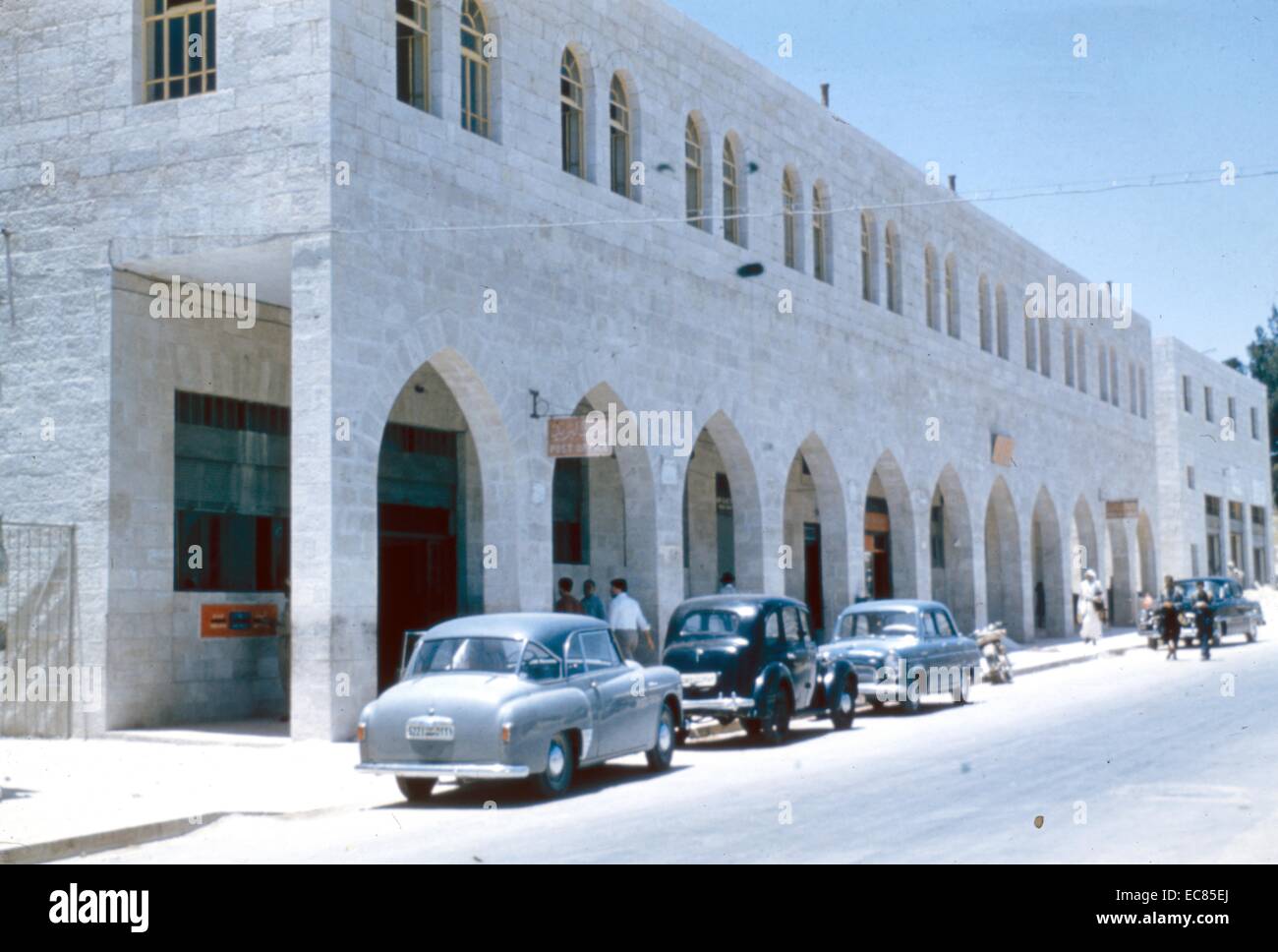 Photographie couleur de voitures à l'extérieur d'un bureau de poste à Jérusalem, pendant le mandat britannique. Datée 1935 Banque D'Images