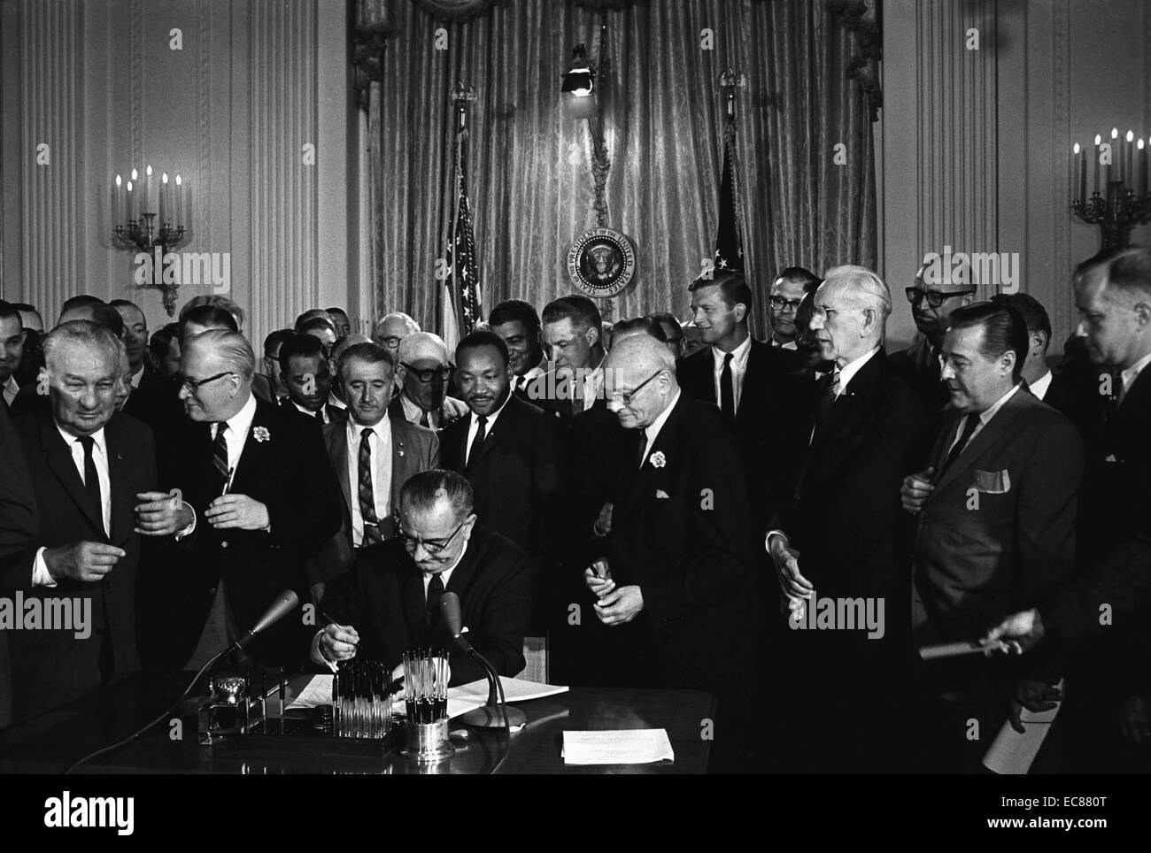 Photographie de Lyndon Johnson, président des États-Unis d'Amérique, la signature de la Loi sur les droits civils. Derrière Johnson est Martin Luther King junior. Datée 1964 Banque D'Images