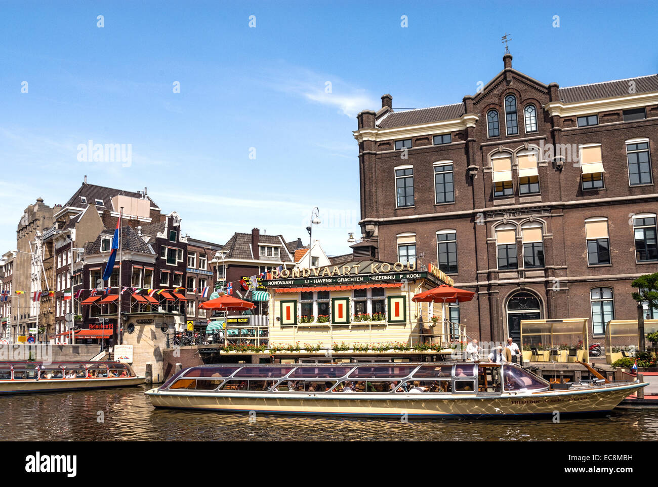 Des bateaux touristiques typiques dans un canal d'eau dans le centre-ville d'Amsterdam, Pays-Bas. Banque D'Images