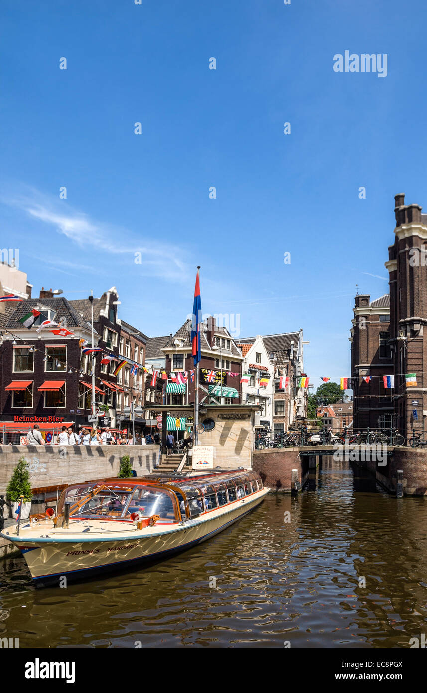 Des bateaux touristiques typiques dans un canal d'eau dans le centre-ville d'Amsterdam, Pays-Bas. Banque D'Images