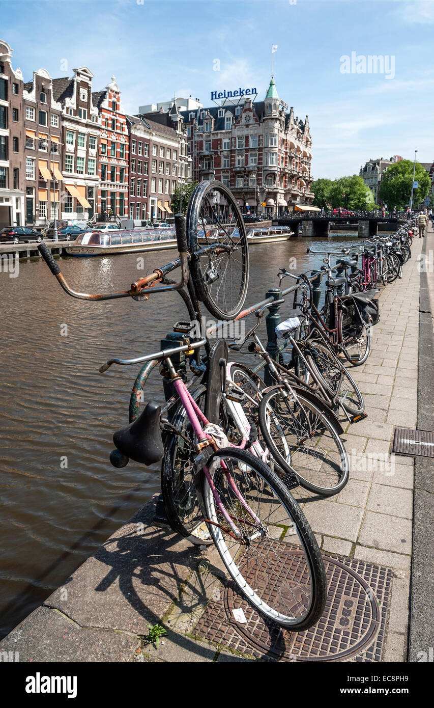 Vieux vélos garés sur une gracht dans le centre-ville d'Amsterdam, Pays-Bas. Banque D'Images