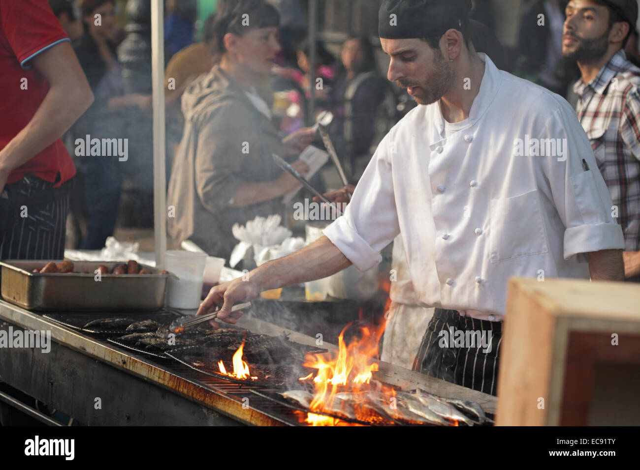 Man grilling sardines fraîches sur un barbecue sur Atlantic Avenue à Brooklyn lors d'une foire de rue Banque D'Images