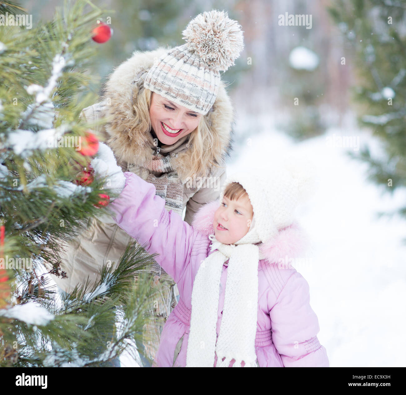 Famille heureuse Mère et enfant jouant avec une décoration d'arbre de Noël Banque D'Images