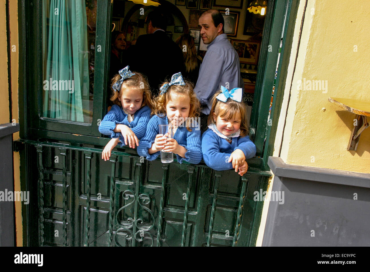 Triplés filles avec des arcs dans les cheveux, même tenue Séville. Espagne générations vieillissantes Banque D'Images